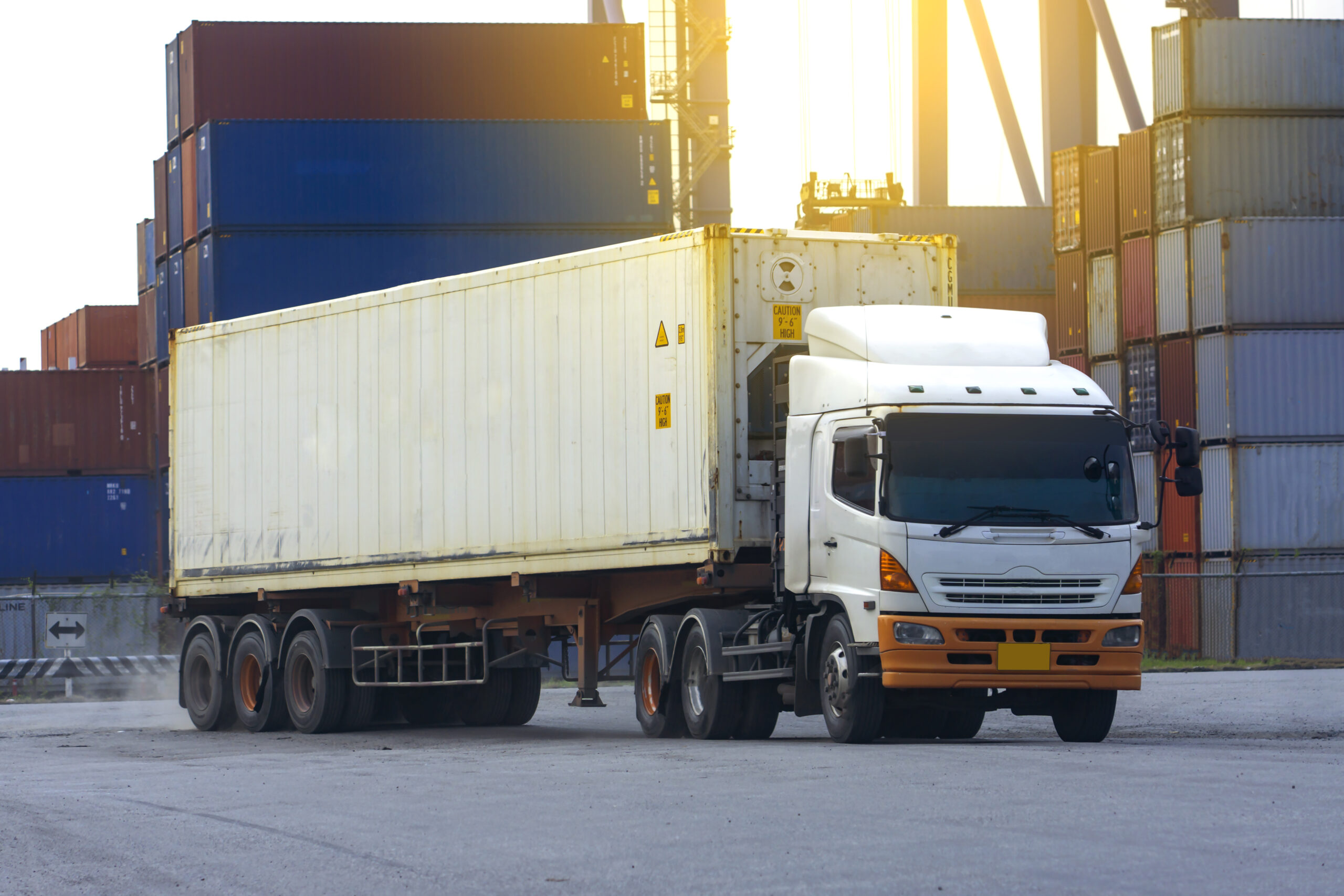 Container white truck in ship port Logistics.Transportation industry in port business concept.import,export logistic industrial Transporting Land transport freight warehouse storge